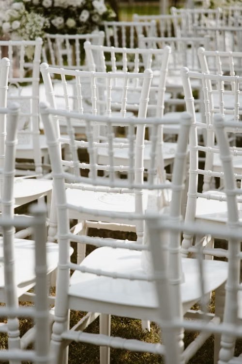 Sedie bianche allestite per la cerimonia all'aperto